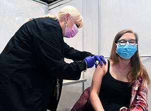 Tessa Pendergraft, Pantex wellness coordinator (right), shares her anxiety of needles, as the medical provider reassures her prior to receiving her COVID 19 vaccine.