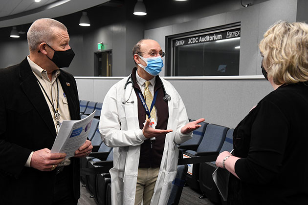 Dr. Paston (center) talks to Geoff Beausoleil, manager of the NNSA Production Office, and Michelle Reichert, CNS president and chief executive officer, at the vaccination clinic. Dr. Paston (center) talks to Geoff Beausoleil, manager of the NNSA Production Office, and Michelle Reichert, CNS president and chief executive officer, at the vaccination clinic.